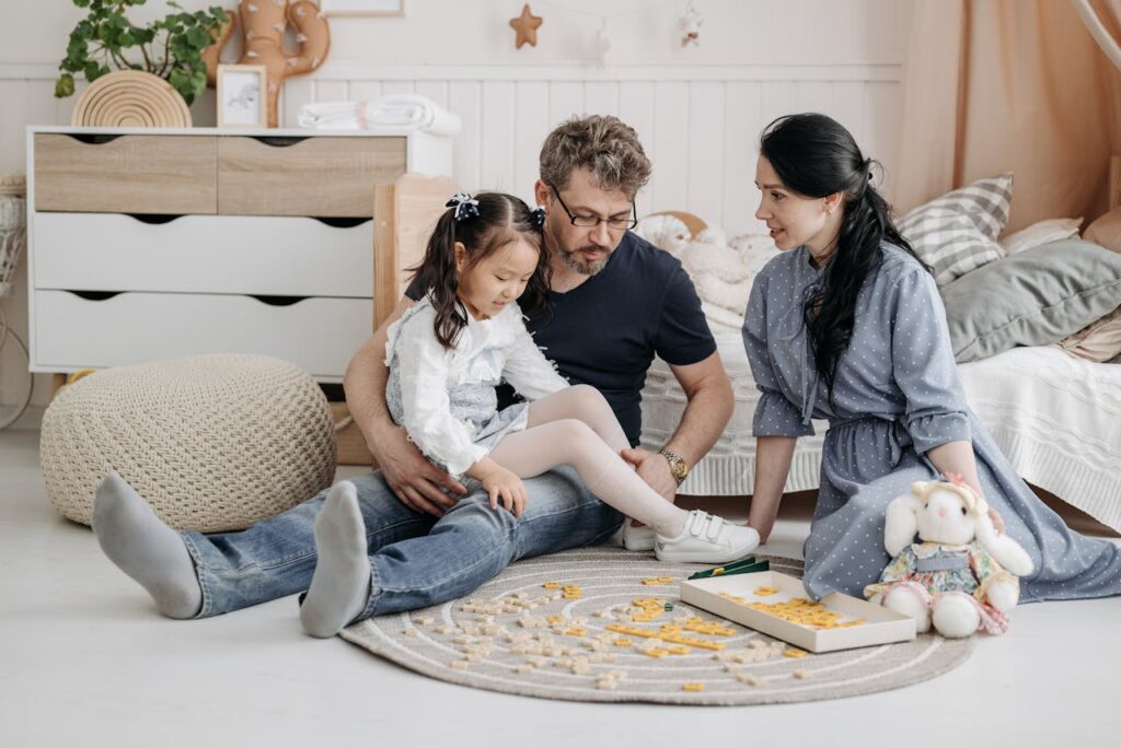 Family playing together on a cozy rug, engaging in a game with colorful pieces, illustrating the nurturing environment of adoption and family bonding in the context of Oklahoma adoption laws.