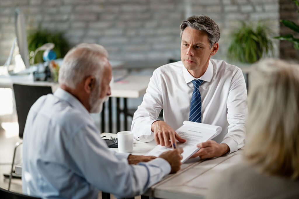 Elder law attorney consulting with senior client, discussing legal documents related to healthcare and asset protection in a professional office setting.